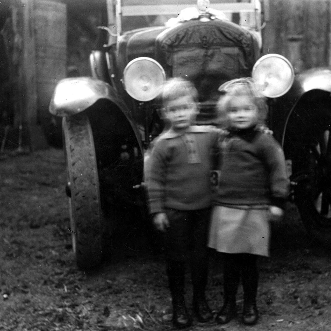 1933: Zwillinge Margarethe und Hans Kurz aus Stuttgart zu Besuch bei den Großeltern Ottilie und Johann Kurz mit ihrem ersten Auto in der Neckartenlinger Straße 19 in Mittelstadt (Quelle: Familie Kern)
